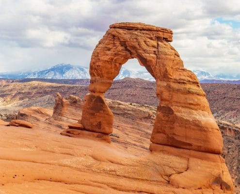 the delicate arch with the la sal mountains behind it. this trail is one of the most popular for hiking in arches national park.