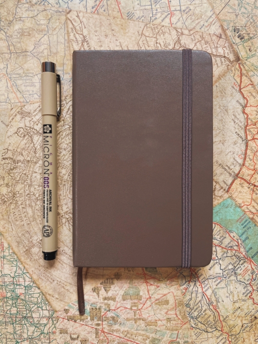 a travel journal notebook and pen should be on your list of things to bring on a plane