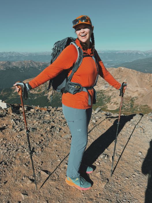 Standing on Gray Peak 14er in Colorado wearing sun gloves and using trekking poles, demonstrating are trekking poles worth it on steep alpine hikes