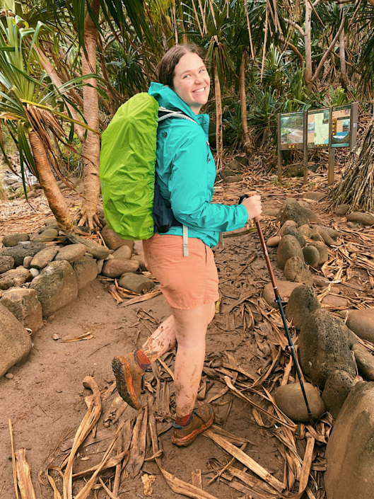 Emma wearing trail runners on a muddy trail with water crossings along the Na Pali Coast in Hawaii
