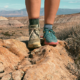 trail runners vs hiking boots comparison showing one of each worn on rocky terrain