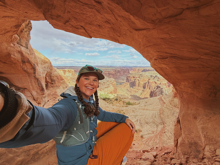 Looking through a window opening in Colonnade Arch with canyon scenery in the background