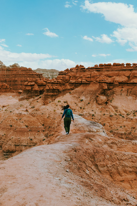 Hiking toward Goblin’s Lair with goblin rock formations in Goblin Valley Utah