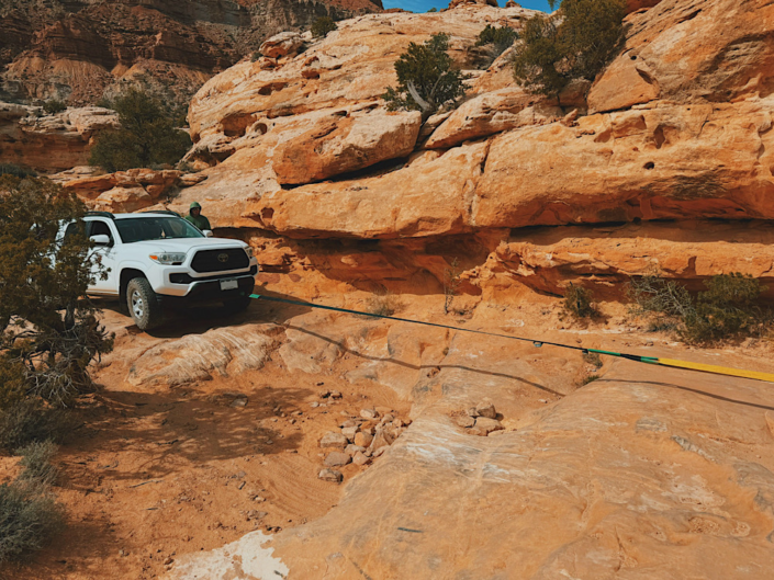 Toyota Tacoma being towed through the Teapot obstacle in the Maze in Canyonlands showing extreme 4WD terrain