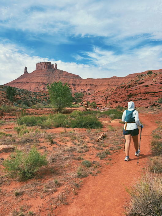 Hiking through the open desert near Mary Jane Slot Canyon with Castleton Tower visible in the background near Moab