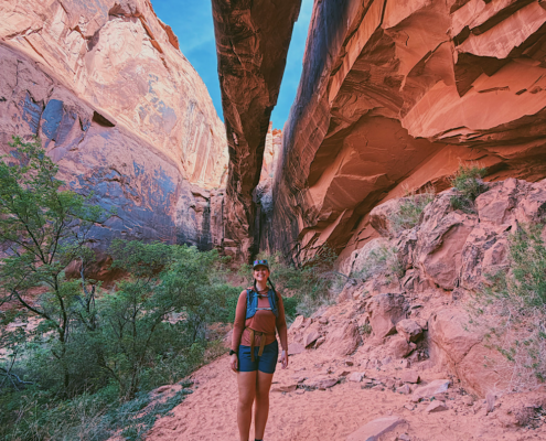 Hiker standing beneath Morning Glory Natural Bridge at the end of the Grandstaff Canyon Trail