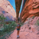 Hiker standing beneath Morning Glory Natural Bridge at the end of the Grandstaff Canyon Trail