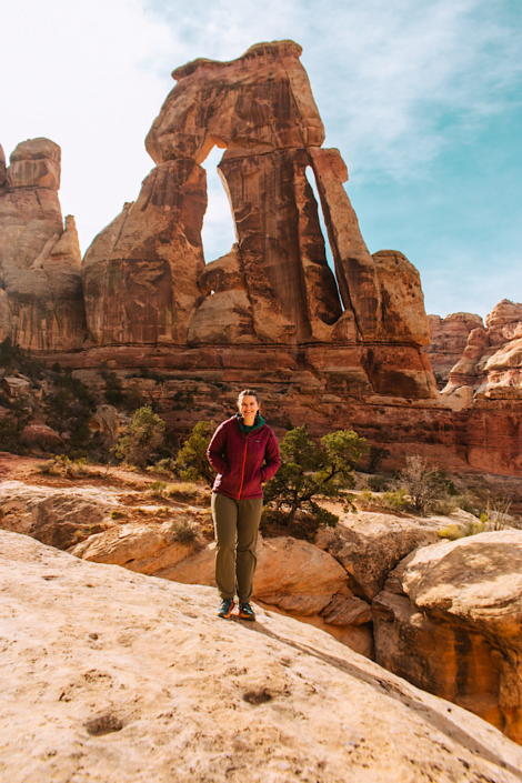 Hiker standing beneath Druid Arch in the Needles District of Canyonlands National Park.