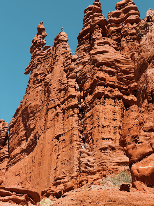 Rock climbers ascending the towering Fisher Towers outside Moab, Utah.