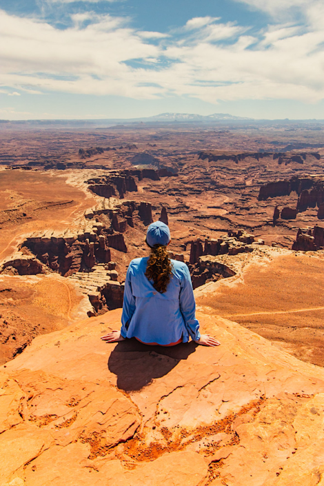 Hiker overlooking the White Rim from White Rim Overlook in Canyonlands National Park.