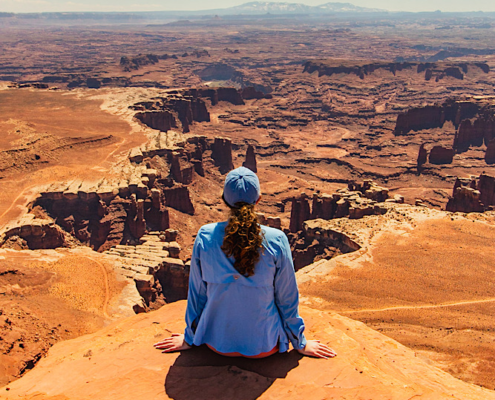 Hiker overlooking the White Rim from White Rim Overlook in Canyonlands National Park.