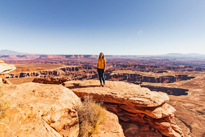 exploring-canyonlands-island-in-the-sky Standing on a rock overlooking Canyonlands National Park in the Island in the Sky District