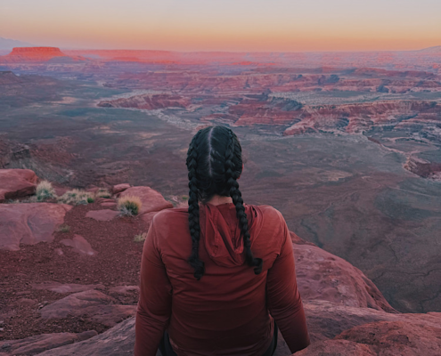 Hiker sitting on a cliff at Panorama Point in the Maze District of Canyonlands National Park