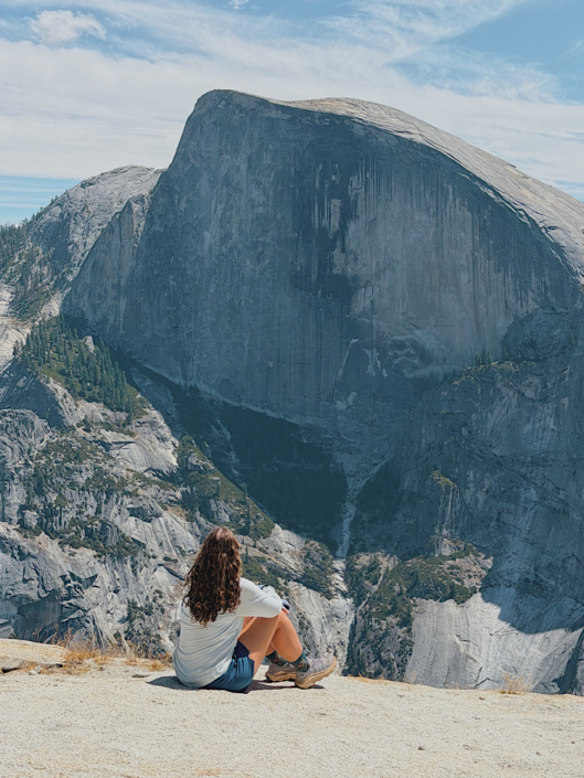 hiker with Half Dome in the background in Yosemite National Park