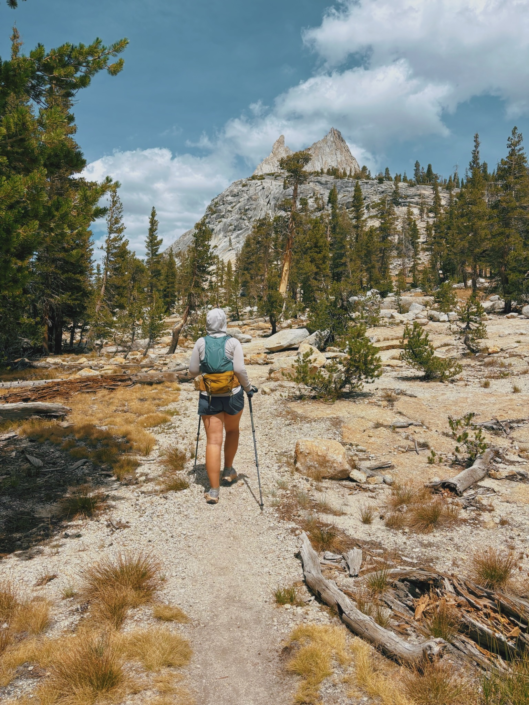 Hiker on the Cathedral Lakes Yosemite trail with Cathedral Peak in the background