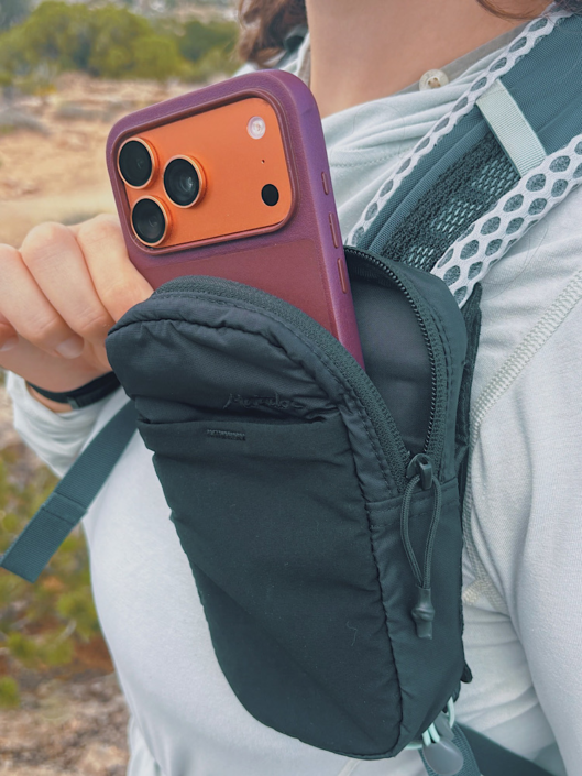 Phone tucked into a Matador Speed Stash attached to a hiking backpack shoulder strap