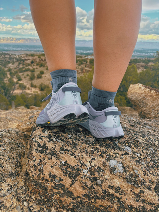 Smartwool merino hiking socks worn with trail running shoes on a desert trail