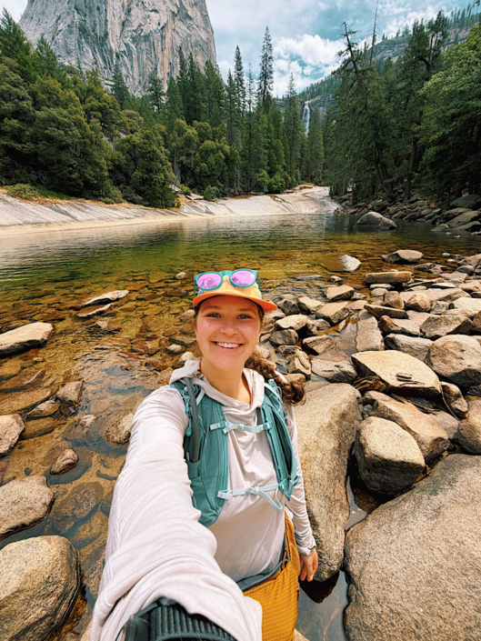 Hiker at Emerald Pool with Nevada Fall visible in the distance in Yosemite